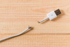 An image featuring an USB cable that is cut in half representing a damaged USB cable