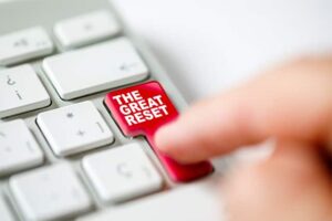 An image featuring a person pressing the enter button that says the great reset