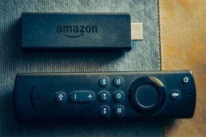 An image featuring the Amazon FireStick device and TV remote