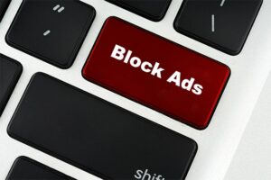 An image featuring a keyboard that has a special red key that says Block Ads on it