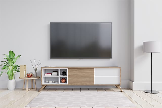 An image featuring a living room with a big TV in the middle hanging on the wall