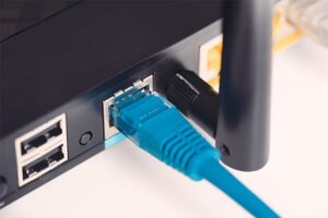 An image featuring an ethernet cable being connected to a router